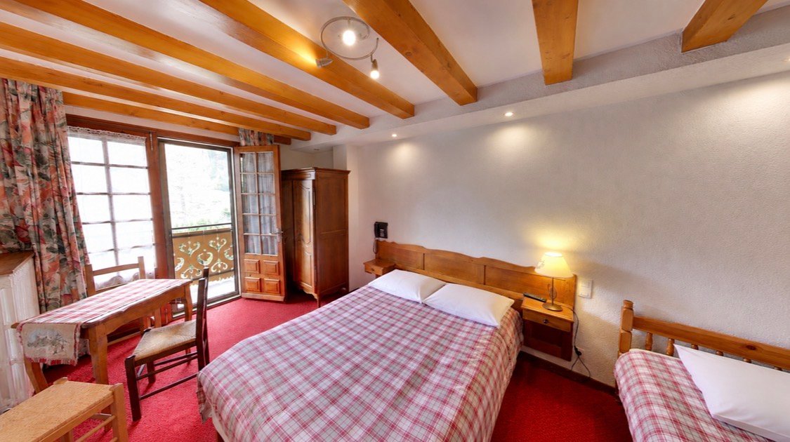 Chambre de l'Hôtel Borderan avec vue sur les sommets de La Clusaz, décoration authentique